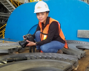 A woman photographs equipment during a steam path audit.